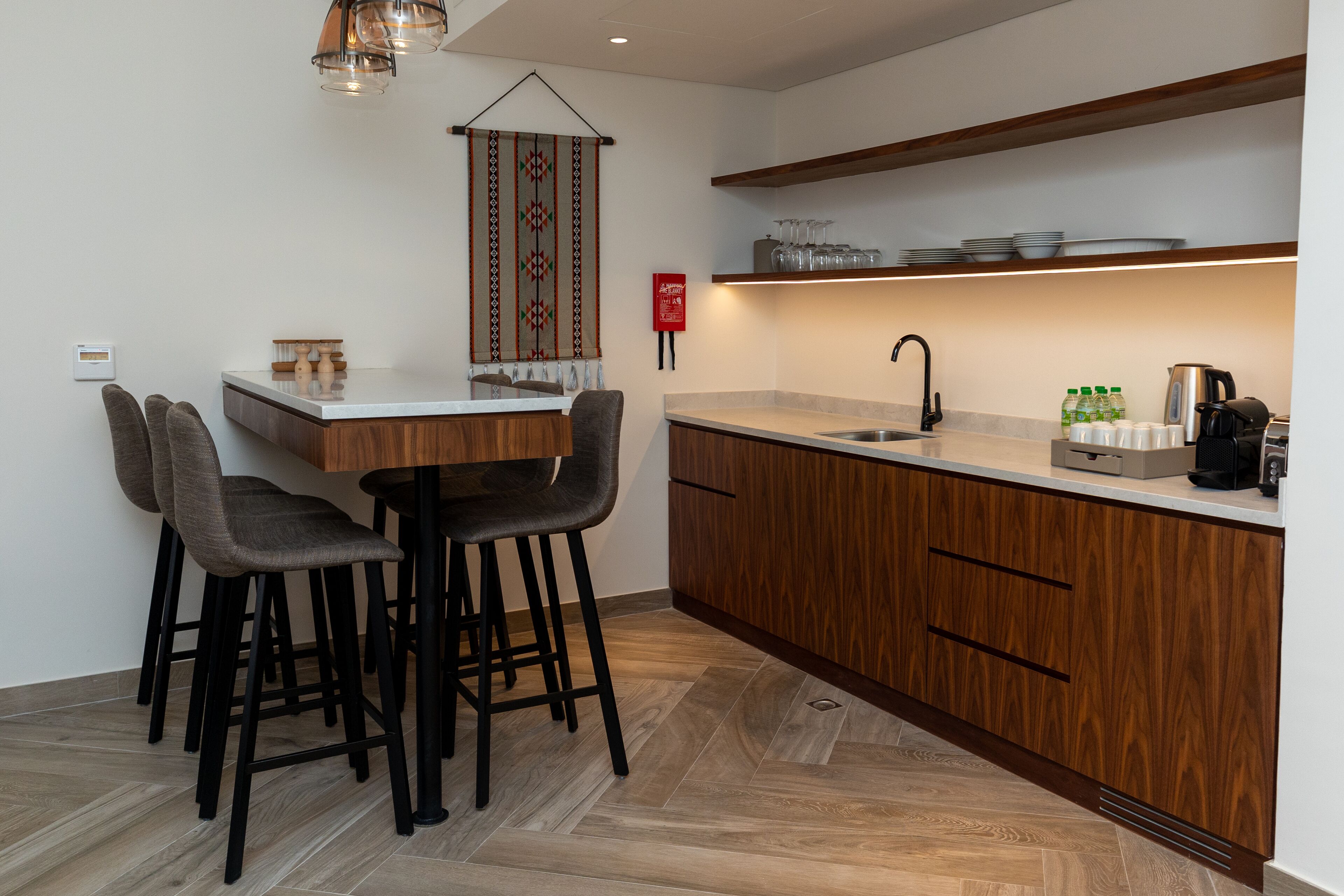 Una cocina moderna con armarios de madera, encimera de mármol y lavaplatos integrado.