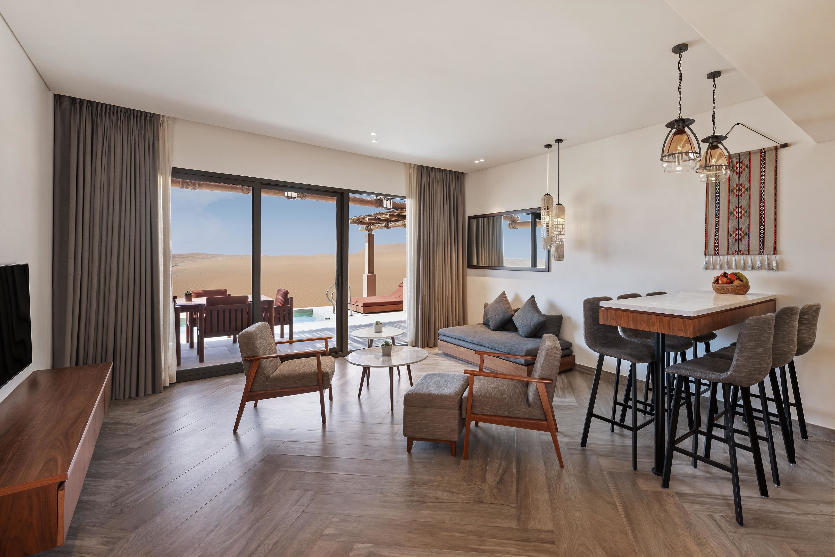 Amplia sala de estar con un ventanal, un sofá, una mesa de comedor y un televisor.