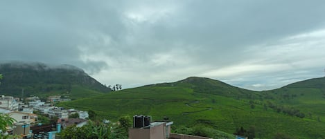 Ein Blick auf eine grüne Hügellandschaft, im Vordergrund ein Wohngebiet.