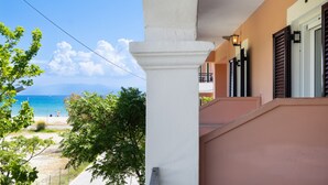 A building with a balcony overlooking a beach and ocean.