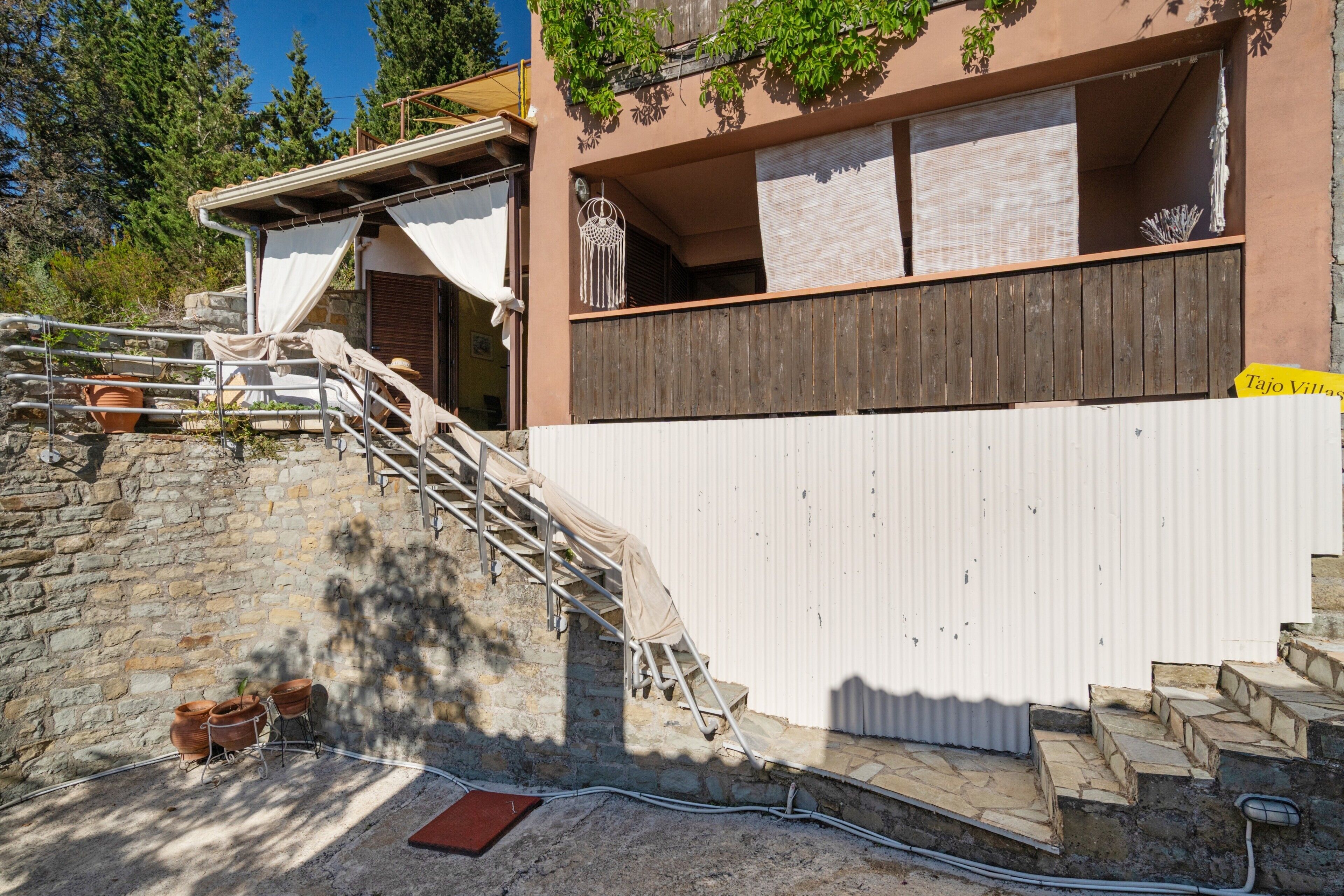 Ein Gebäude mit einer Steintreppe, einem Metallgeländer und einer weißen Wand.