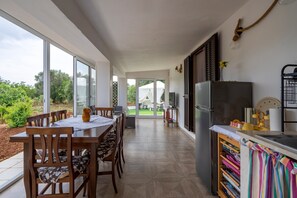 Eine moderne Küche mit Essbereich, großen Fenstern und Blick ins Freie.