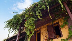 A building with a yellow facade, wooden beams, and windows with brown shutters. - Apartment 'Villa Rojo Tajo Villas' with Sea View, Wi-Fi and Air Conditioning (Lefkada)