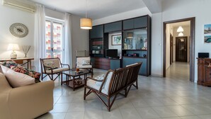 A living room with a sofa, chairs, a coffee table, a TV, and a bookshelf. - Apartment "Chicca Casa Vacanze" with Private Terrace & Wi-Fi (Bari)