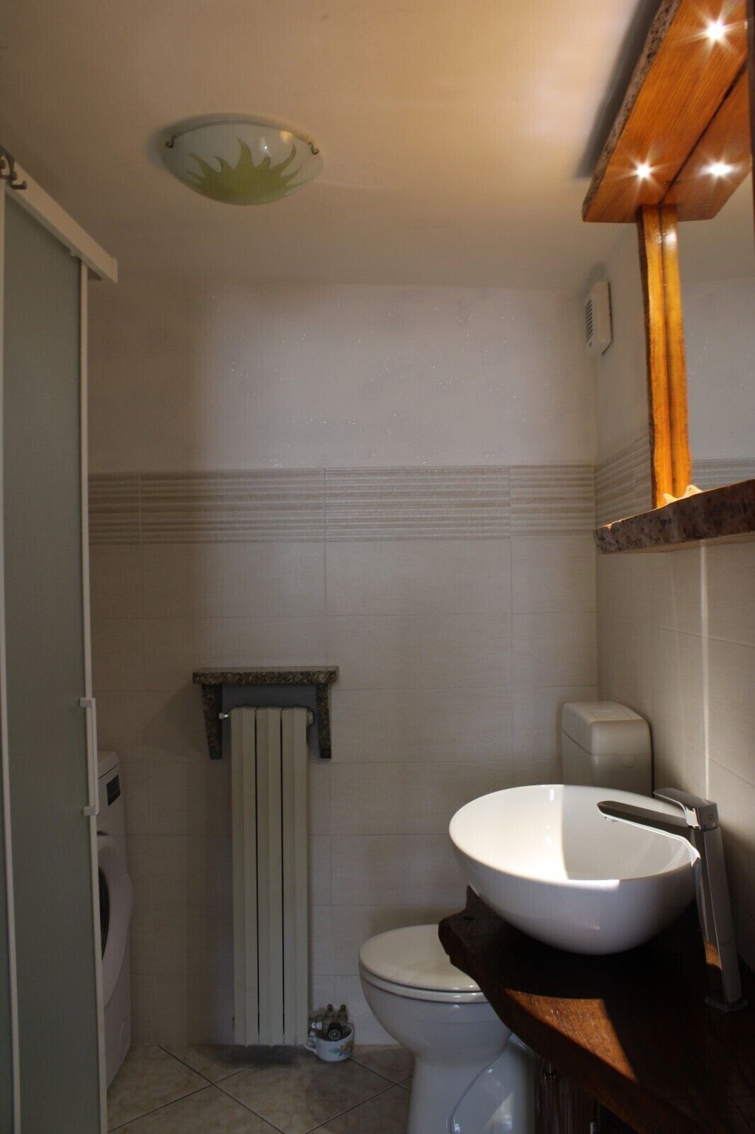 A bathroom with a toilet, a sink, a shower, and a towel rack.