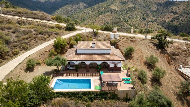 Eine Villa mit Swimmingpool, Außenbereich und Blick auf die umliegenden Hügel.