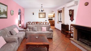 Ein Wohnzimmer mit Kamin, zwei Sofas, einem Couchtisch und einem Essbereich mit Stühlen.
