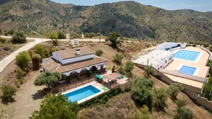 Eine Villa mit Swimmingpool, Terrasse und Blick auf die umliegenden Hügel.