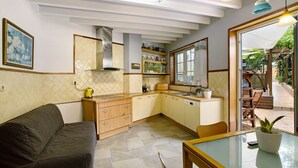 Une cuisine compacte avec un canapé, une table à manger et une vue sur l’extérieur.