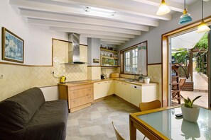 Una cocina compacta con sofá, mesa de comedor y vistas al exterior.