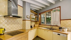 Une cuisine équipée d’une cuisinière intégrée, d’un lave-vaisselle et d’une fenêtre avec des rideaux.
