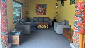 Una sala de estar con un sofá, una mesa de centro y elementos decorativos como un cuadro y adornos de pared.