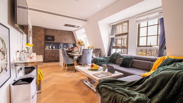 Un salon moderne comprenant un canapé, une table basse et un coin repas avec des chaises et une table.