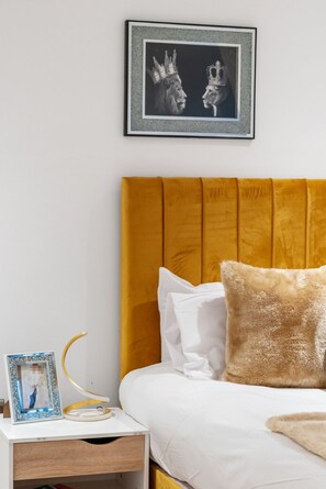 Cozy retreat with a bed, nightstand, and framed photo.