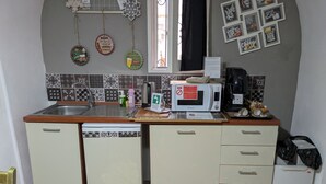 Une cuisine compacte équipée d’un four à micro-ondes, d’un évier et d’une machine à café.