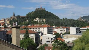 Un pueblo con edificios y una colina con una torre.