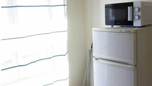 Una kitchenette pequeña con microondas y refrigerador.
