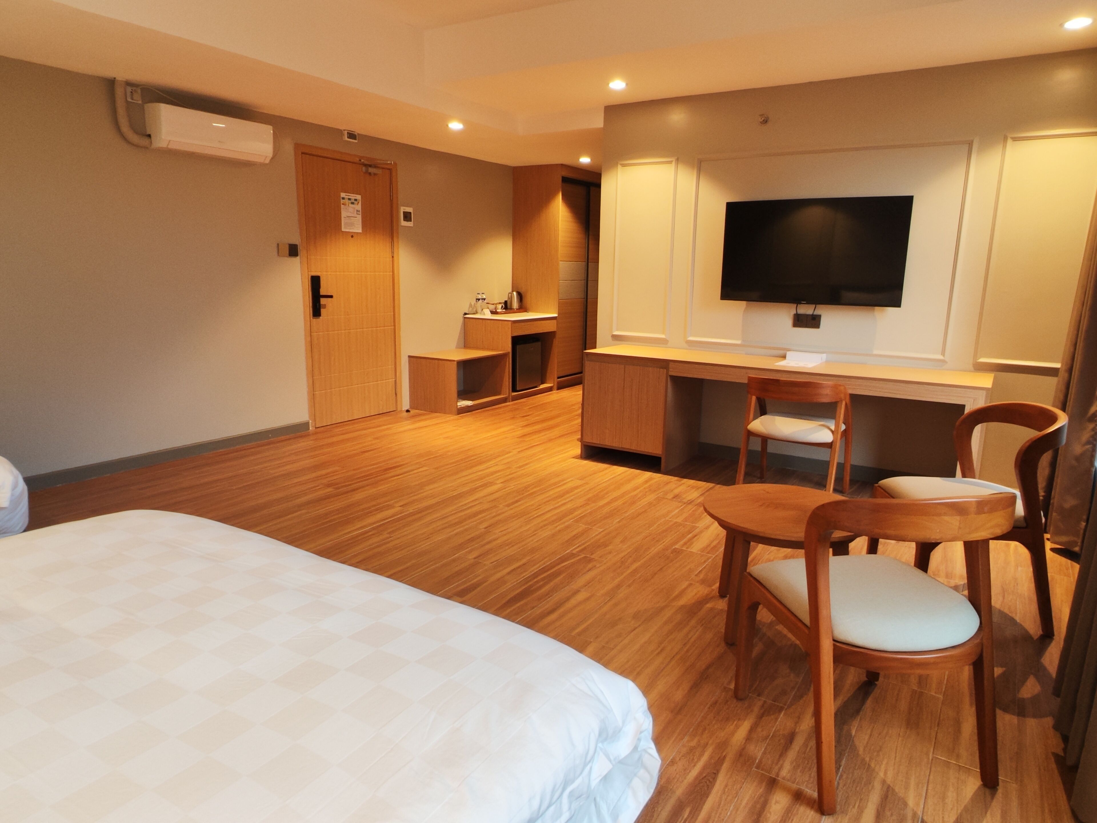 Une chambre d’hôtel équipée d’un lit, d’un bureau, d’une chaise, d’une télévision et d’une kitchenette.