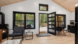 A modern interior with large windows, a fireplace, and a dining area.