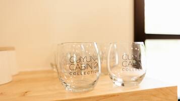 Two clear glass cups with the text "CUYUNA CABIN COLLECTION" on a wooden surface.