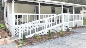 A single-story mobile home with a covered porch and a fenced deck area. - Magical Location on the River, Hiking, and Rafting (Sylva)