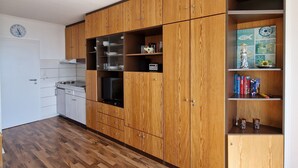 Eine Küche mit Holzausstattung, einem Einbauofen und einer Mikrowelle.