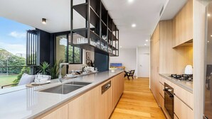 Uma cozinha moderna com uma ilha grande, eletrodomésticos embutidos e vista para o exterior.