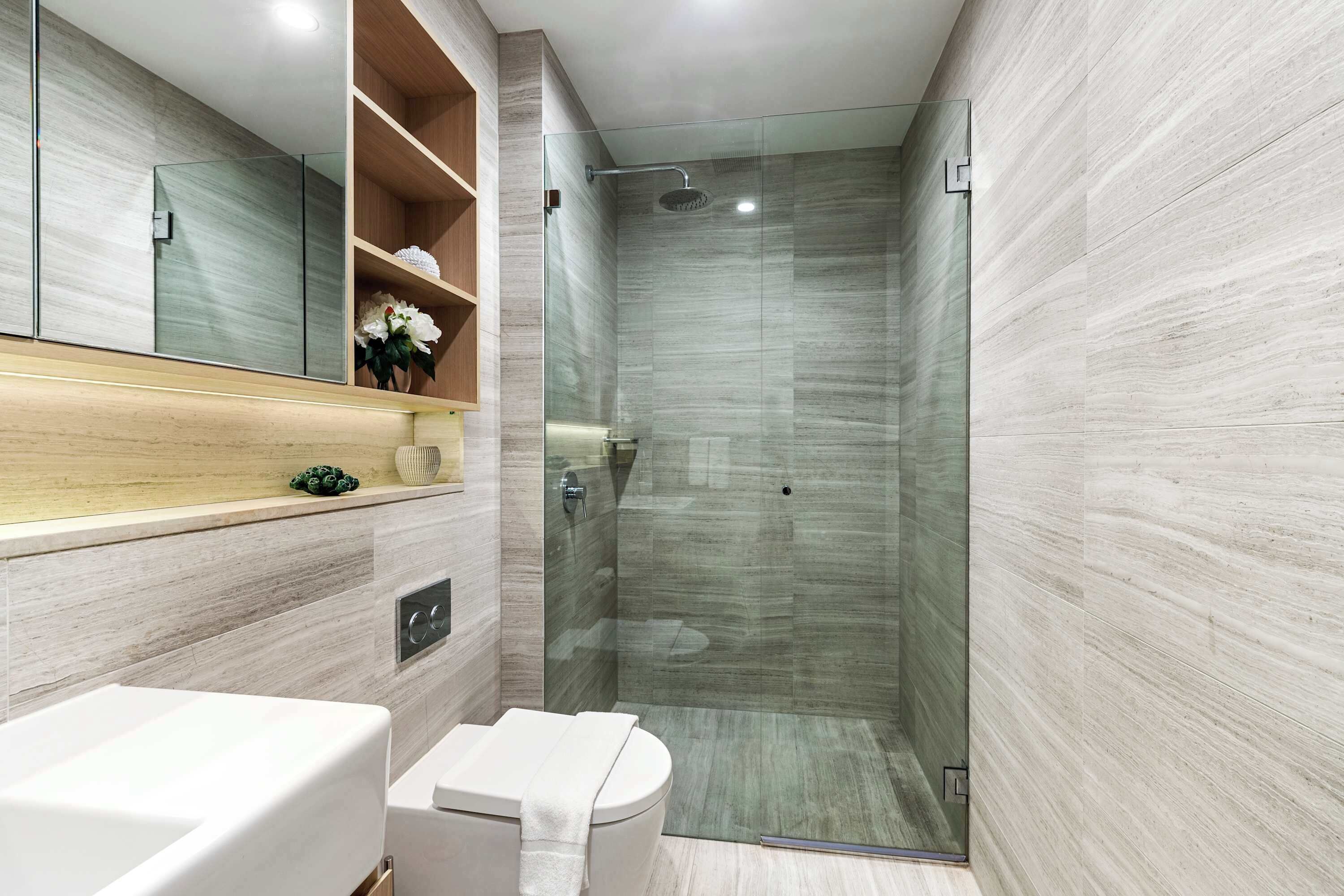 A modern bathroom with a glass-enclosed shower, a toilet, and a vanity with a mirror and shelves.