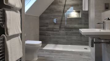 Un baño moderno con tragaluz, inodoro, bañera y lavamanos.