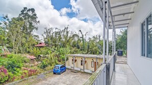 A residential area with a blue car parked in front of a house with a tiled roof. - Hotel O Susupuan KostNearTaman Deki Lestari (Tondano)