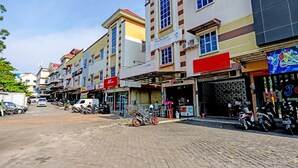 A street with buildings, parked vehicles, and a clear sky. - Hotel O Zazezo Homestay Syariah (Tanjung Pinang)
