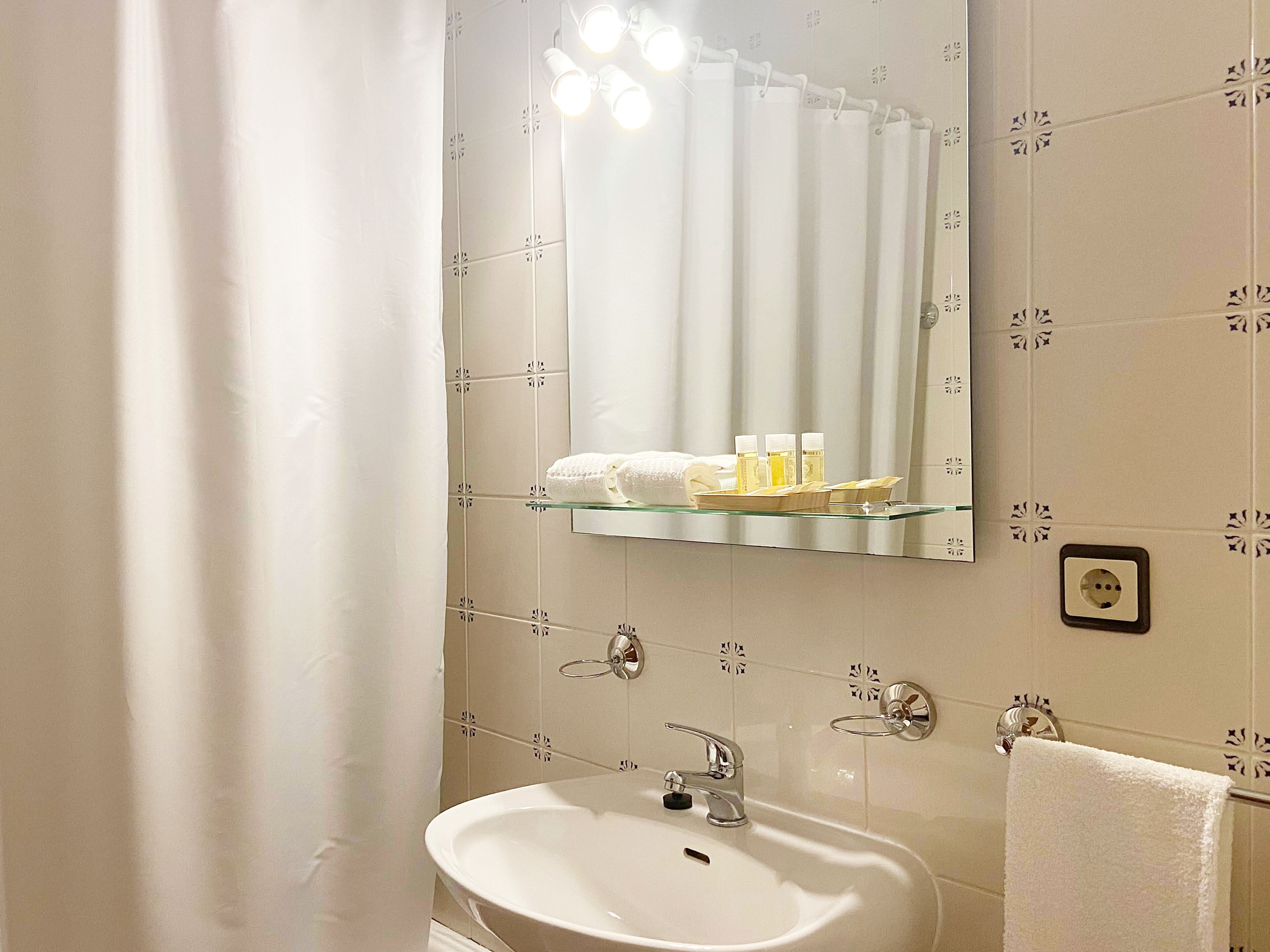 A bathroom with a white sink, a mirror, and a towel rack.