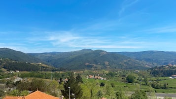 A view of a valley with green hills and a clear blue sky.
