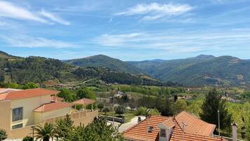 A residential area with terraced houses, a clear sky, and rolling hills in the background.