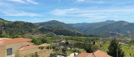 A residential area with terraced houses, a clear sky, and rolling hills in the background.