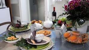 A dining table set with plates, bowls, glasses, and a bottle of wine. - 1 Bedroom Guesthouse in Matera (Matera)