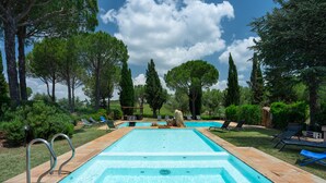 A rectangular swimming pool with two diving boards, surrounded by lounge chairs and trees. - Villa Monte Bottigli (Grosseto)