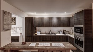 Una cocina moderna con armarios de madera oscura, electrodomésticos de acero inoxidable y una isla central con papeles.