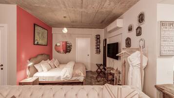 Een slaapkamer met een bed, een bank, een kaart aan de muur en een televisie.