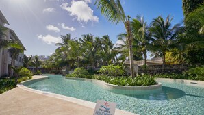 A clear swimming pool surrounded by palm trees and a sign indicating '2Futures Holidays'. -  Ki Residences with LOV (Grand-Baie)