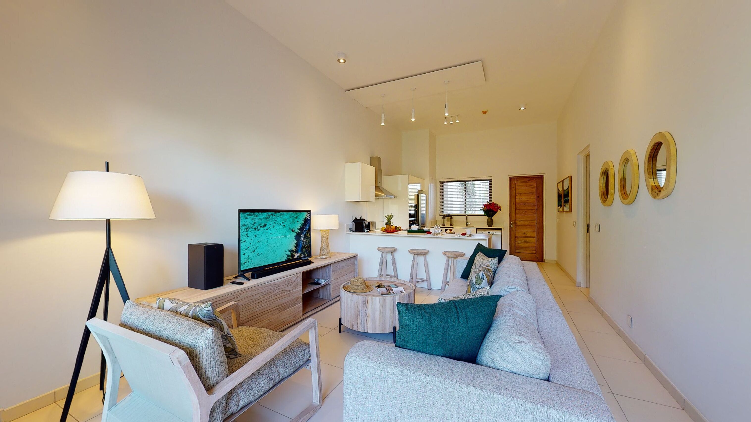 A modern living room with a flat-screen TV, a lamp, a sofa, and a coffee table.
