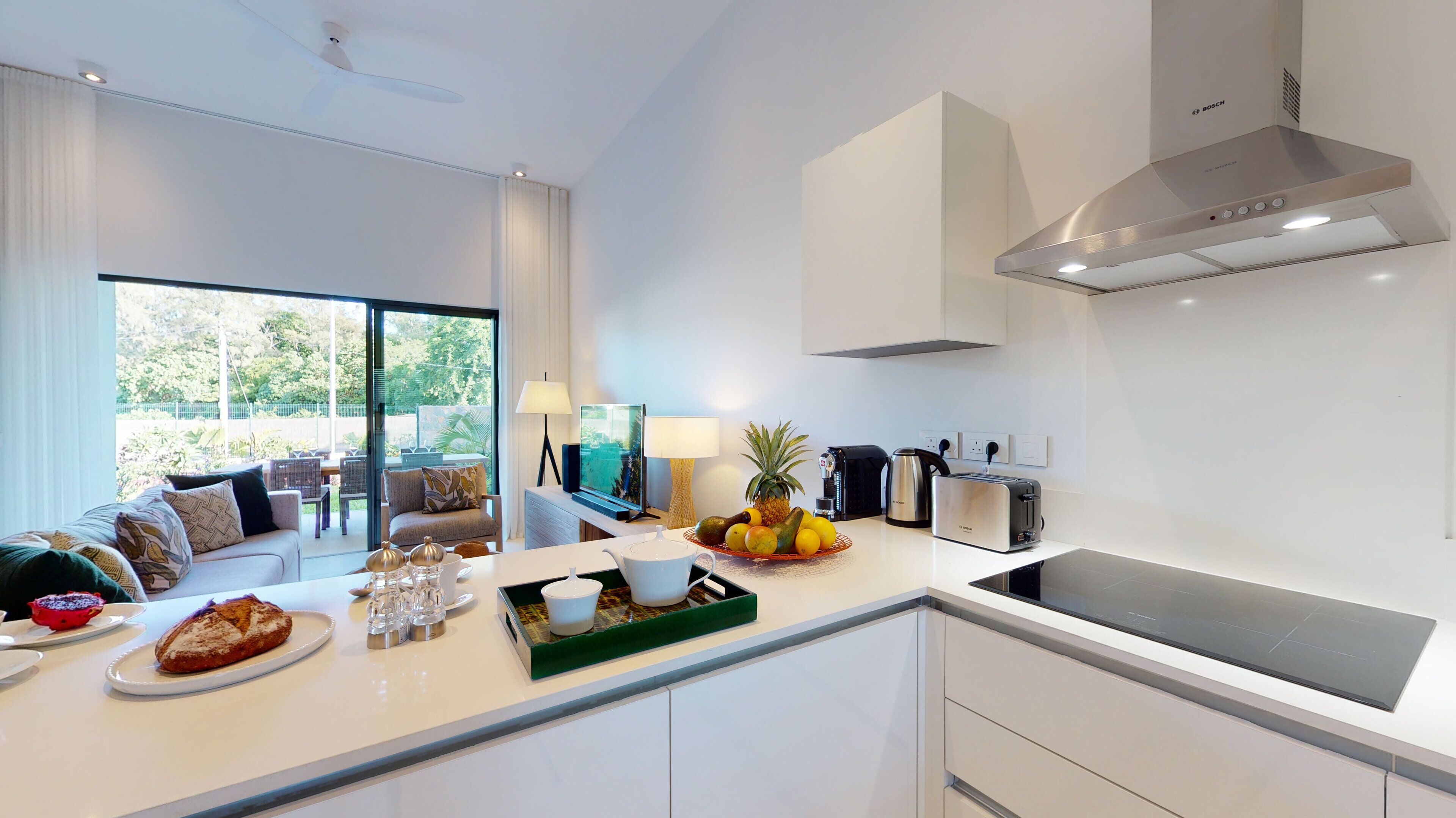 Una cocina moderna con estufa integrada, cafetera y frutero.