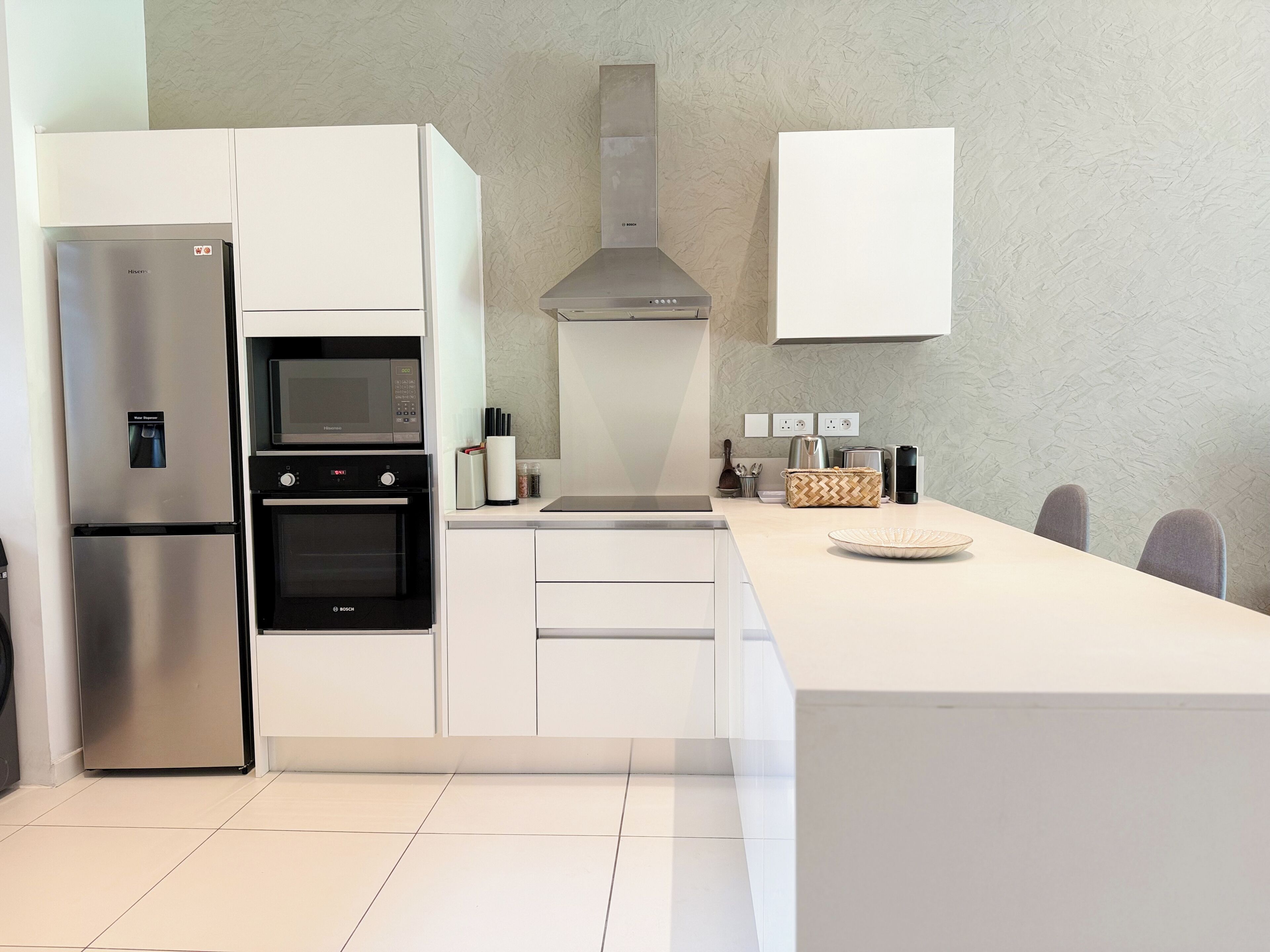 Una cucina moderna dotata di frigorifero integrato, forno, microonde e piano cottura.