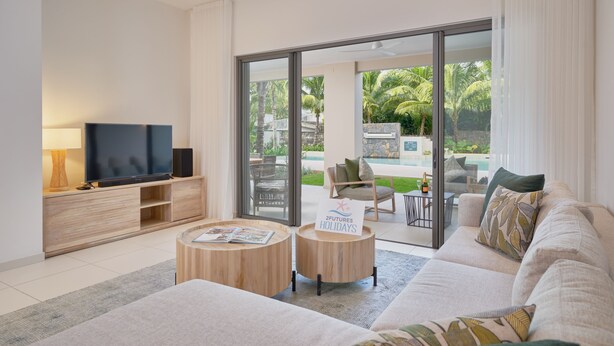 A modern living room with a flat-screen TV, wooden coffee table, and a sofa. -  Ki Residences with LOV (Grand-Baie)