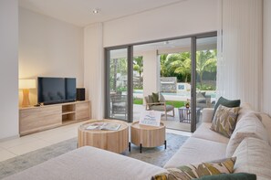 A modern living room with a flat-screen TV, wooden coffee table, and a sofa.