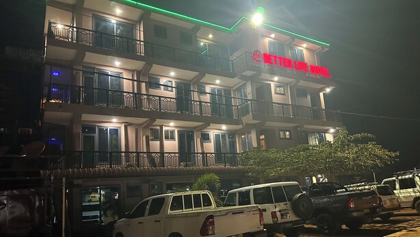 Een meerhoog hotel met balkons en een bord waarop 'BETTER LIFE HOTEL' staat.