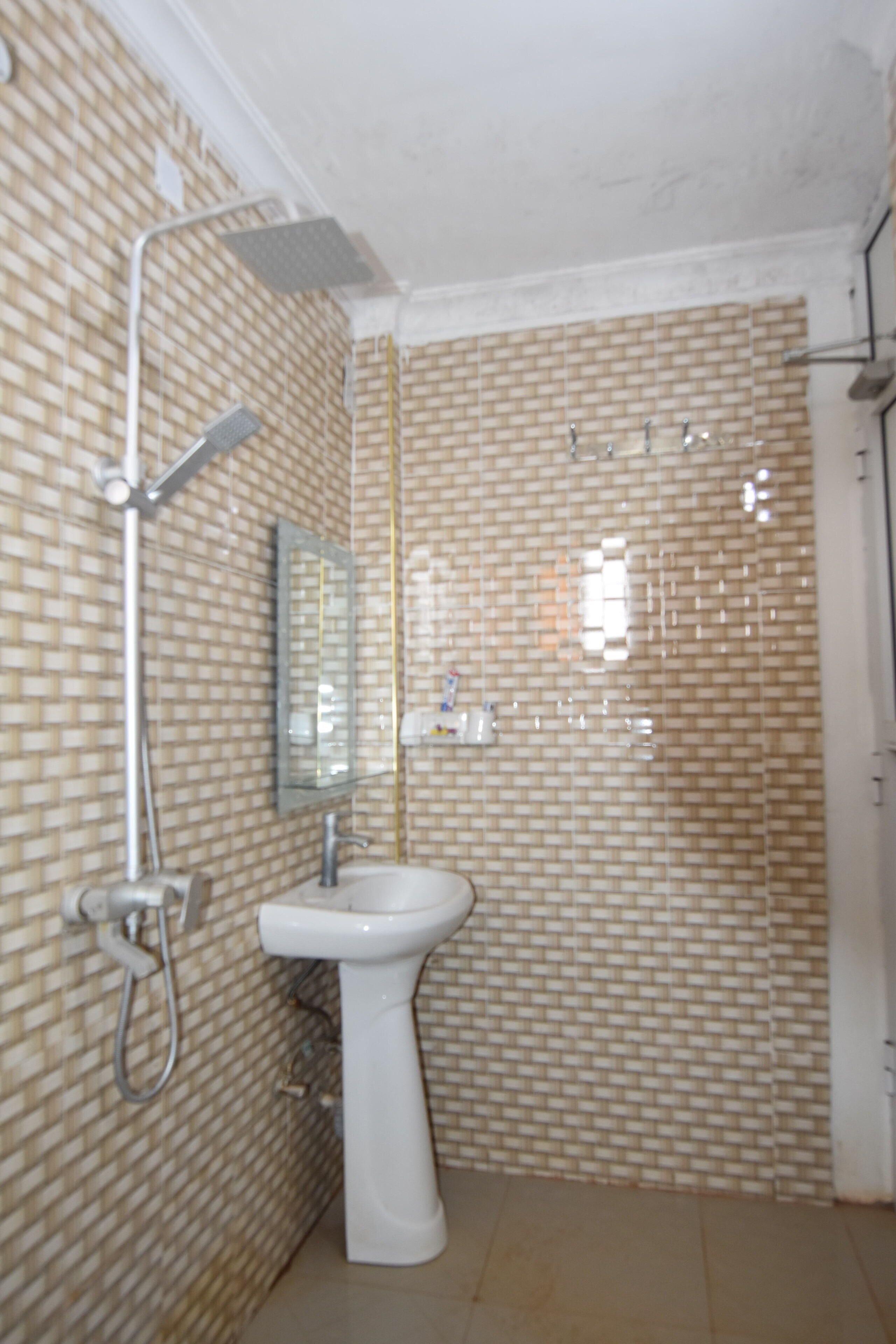 A bathroom with a white sink, a mirror, and a shower.