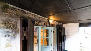 The entrance to the Boathouse Theatre with a rustic stone wall and a wooden door. - The Boathouse, St Ives – Sleeps 4 – Dog-Friendly (St Ives)