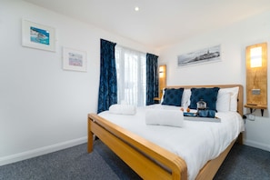 Relax in a spacious room with a large bed, bedside table, and comfortable seating area.