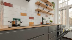 Una cocina con mostrador de madera, una olla en la estufa y un lavavajillas.